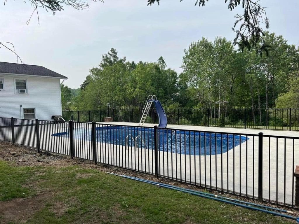 Metal fence surrounding pool area from Timberland Fence & Land, the fence experts